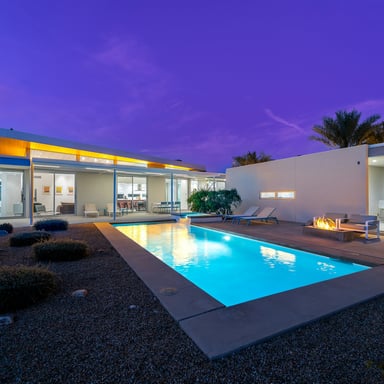Luxury desert home with pool lit up at night