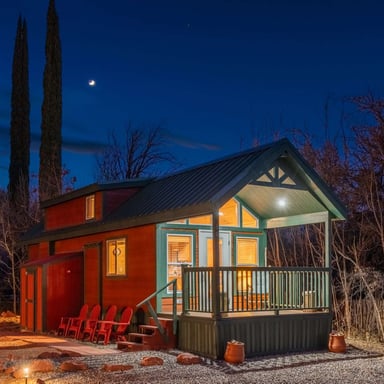 Sedona cabin at night with red rocks and cypress trees