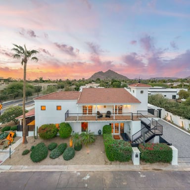 White Spanish-style home with Camelback Mountain at sunset