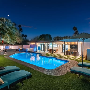 Scottsdale pool at night with palm trees and string lights